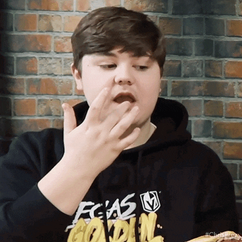 a young boy wearing a black hoodie that says fcas golden