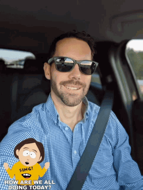 a man wearing sunglasses and a yellow shirt that says sing is driving a car
