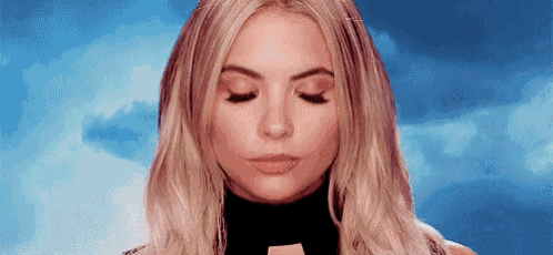 a close up of a woman 's face with her eyes closed in front of a blue sky .