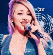a woman is singing into a microphone in front of a globe .