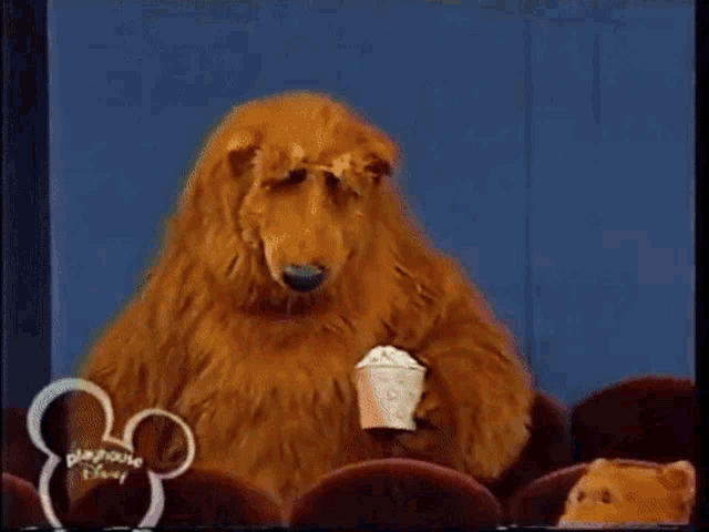 a group of stuffed animals are sitting in a theater with a disney logo in the corner
