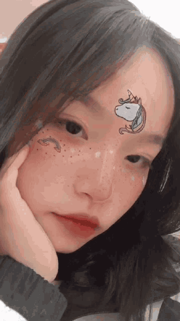 a girl has a unicorn on her forehead