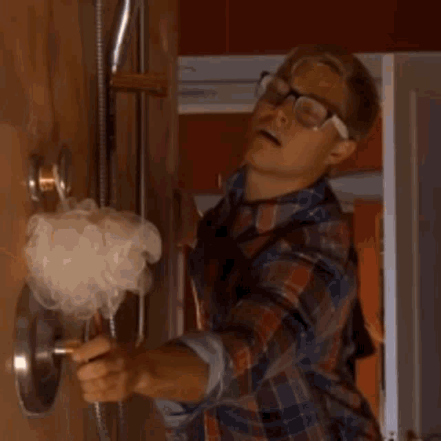 a shirtless man is taking a shower with the water coming down his chest