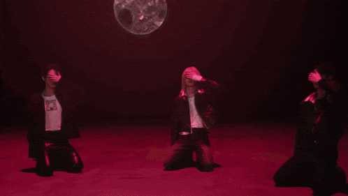 three people covering their eyes in a dark room