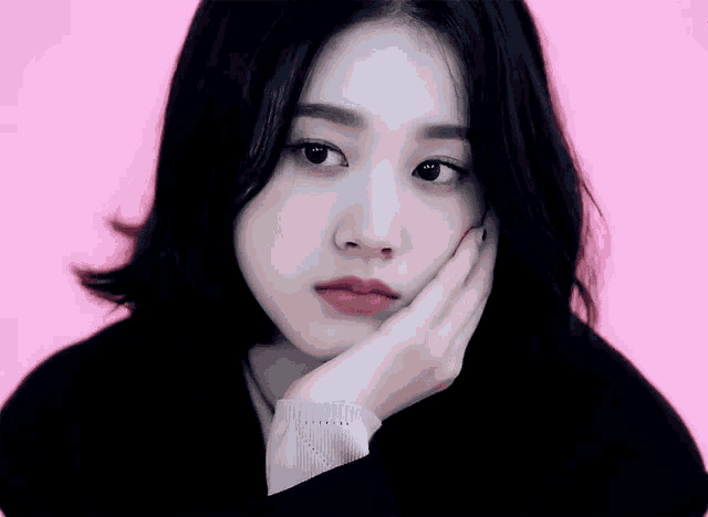 a close up of a woman 's face on a pink background