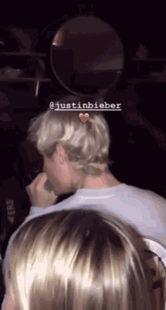 a man with a tattoo on his neck is holding a microphone and has the name justin bieber above his head