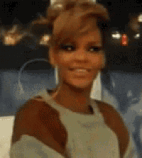 a woman is smiling and looking at the camera while wearing a sweater .