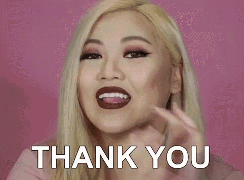 a woman is smiling and saying thank you with her hands folded .