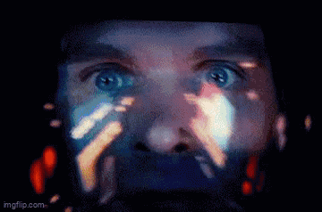 a close up of a man 's face with a reflection of a person 's face on the screen .