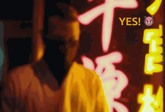 a man stands in front of a neon sign that says " yes "
