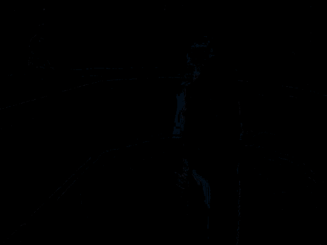 a man with a beard is standing in a dark room while another man sits on a bench