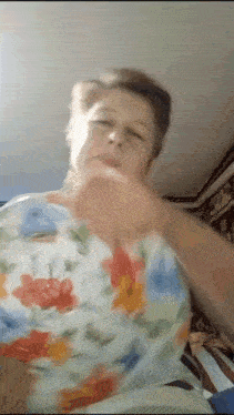 a woman in a floral shirt is making a face
