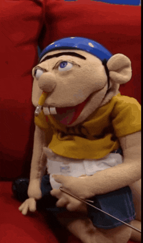 a puppet with a diaper on is sitting on a couch