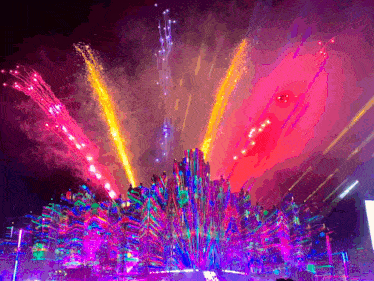 a colorful fireworks display at night with a purple background