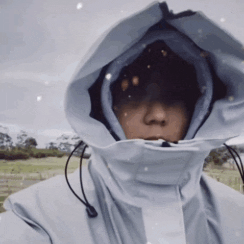 a person in a white jacket with a hood