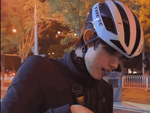 a man wearing a trek helmet is looking down