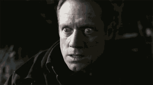 a close up of a man 's face with a dark background