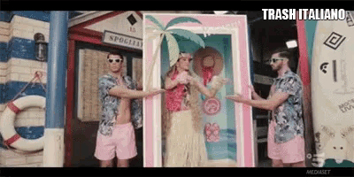 a group of men are standing around a barbie doll in a pink frame .