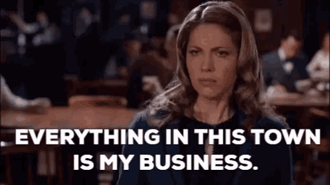 a woman is sitting at a table in a restaurant and saying `` everything in this town is my business '' .
