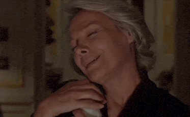 a woman with gray hair is laughing with her hand on her mouth