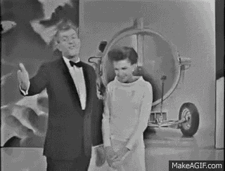 a black and white photo of a man in a tuxedo and a woman in a white dress .