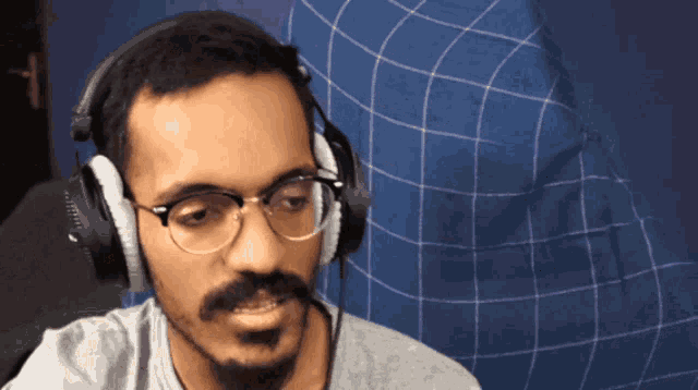 a man wearing glasses and headphones looks at something