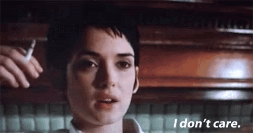 a woman is smoking a cigarette in a kitchen and saying `` i don 't care '' .