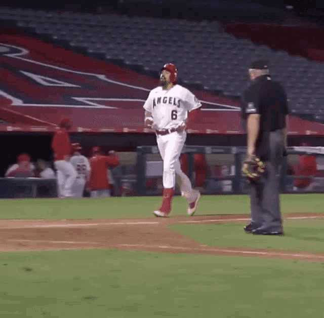 a baseball player for the angels is walking towards the base