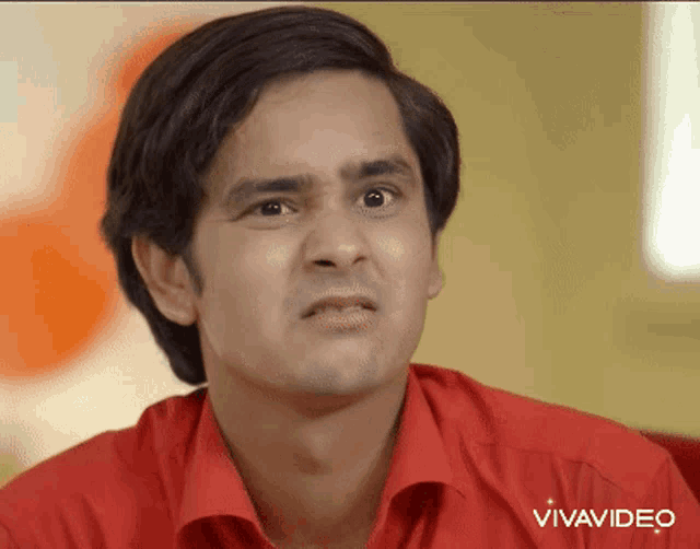 a man in a red shirt is making a funny face with vivavideo written in the corner
