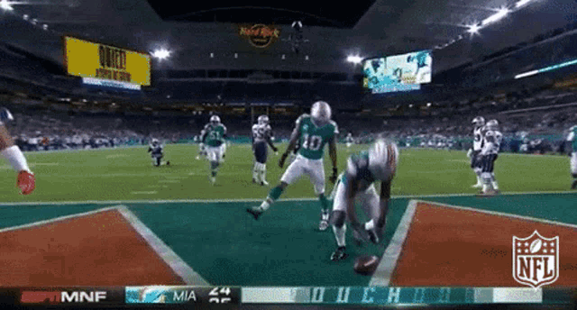 a football game is being played at a stadium with a hard rock sign in the background