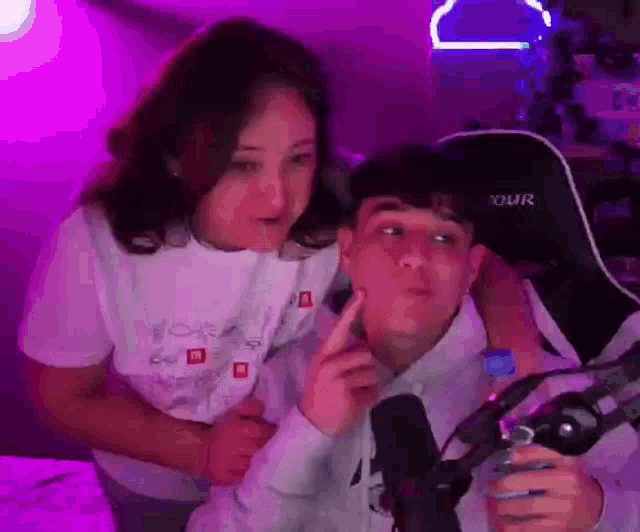 a man and a woman are sitting next to each other in front of a microphone in a room .