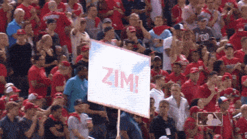 a man holds up a sign that says zima