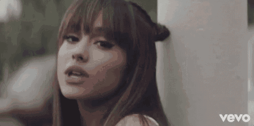 ariana grande is leaning against a wall in a video for her song .