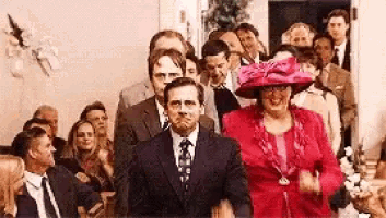 a man in a suit and tie is walking down the aisle at a wedding .