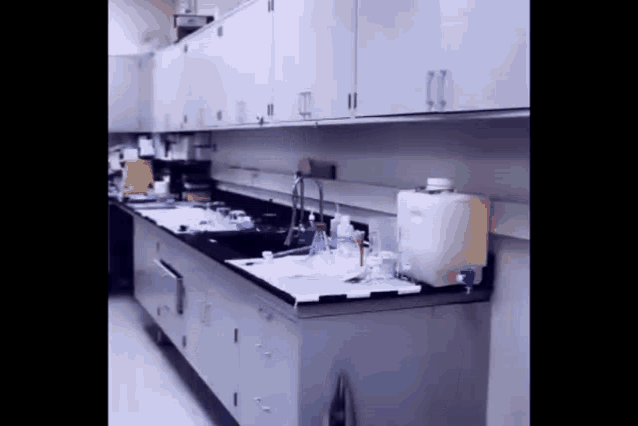 a laboratory with a sink and a large white container
