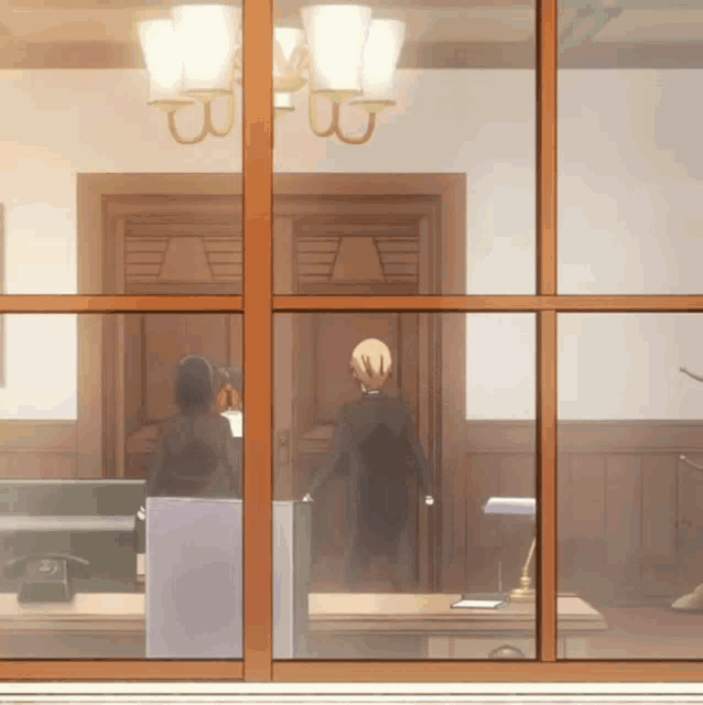 a man in a suit is standing in front of a door with the letter b on it