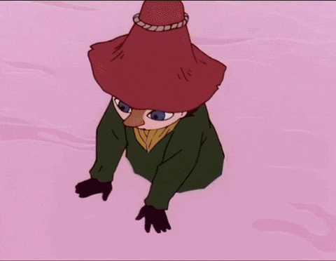 a purple cartoon character is laying on a pink surface holding a ribbon .