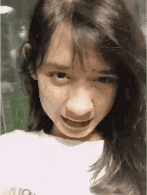 a close up of a girl making a funny face with her mouth open .