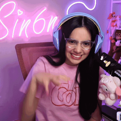 a woman wearing headphones and a pink shirt has the name simon on the wall behind her
