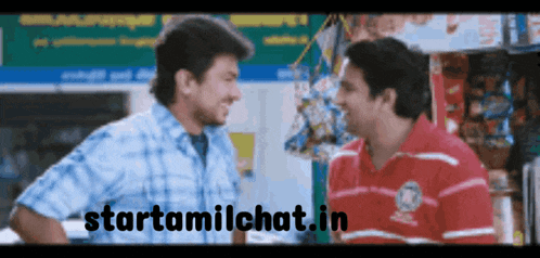 two men talking in front of a sign that says starttamilchat.in on it