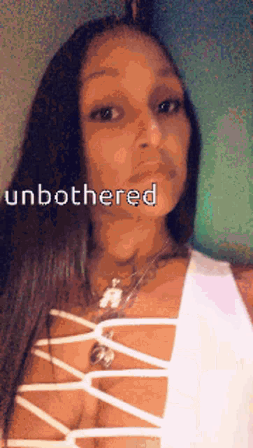a woman in a white lace up top with the word unbothered on her face