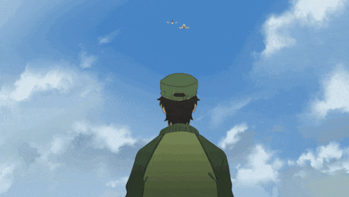a man in a green hat is looking up at a blue sky