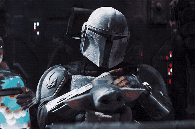a close up of a star wars character wearing a helmet and holding a gun
