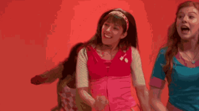a girl in a pink shirt is holding hands with another girl