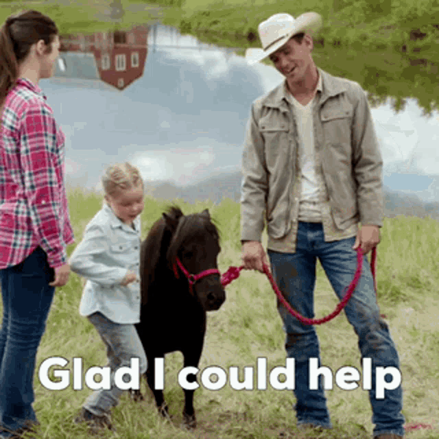 a man in a cowboy hat is holding a pony on a leash while a woman and child look on ..