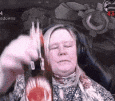 a woman wearing headphones and a scarf is holding a knife to her head .