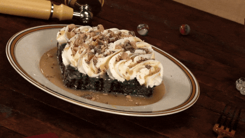a piece of cake with whipped cream and caramel sauce on a white plate