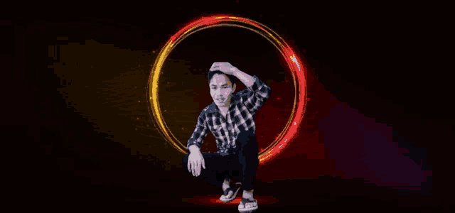 a man in a plaid shirt is squatting in front of a red circle .