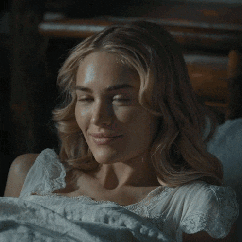 a woman laying in bed with the words i love you written on her face