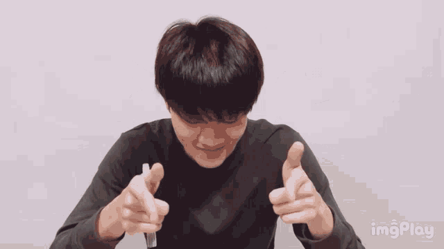 a man is pointing at the camera with hearts around his head and the words imgplay on the bottom right